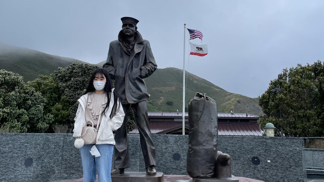 Anna Nishida poses in front of a statue