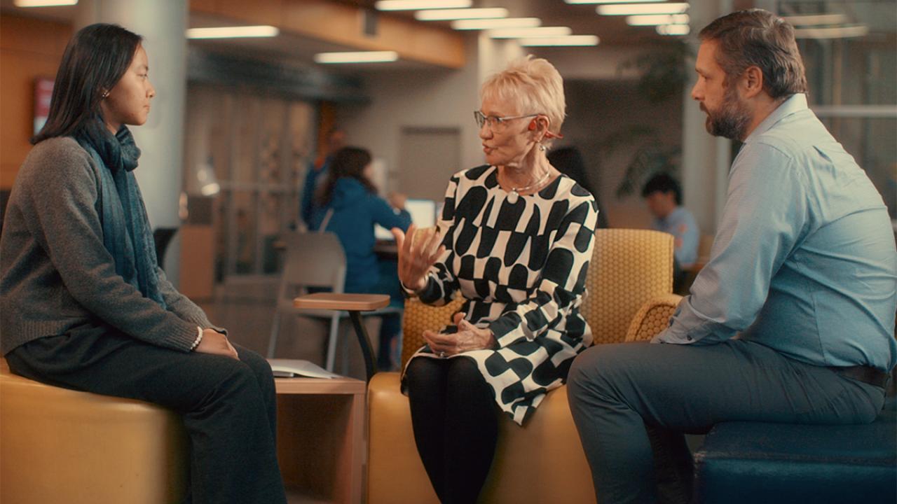 Anneli Adams talks with a student and colleague at the International Center