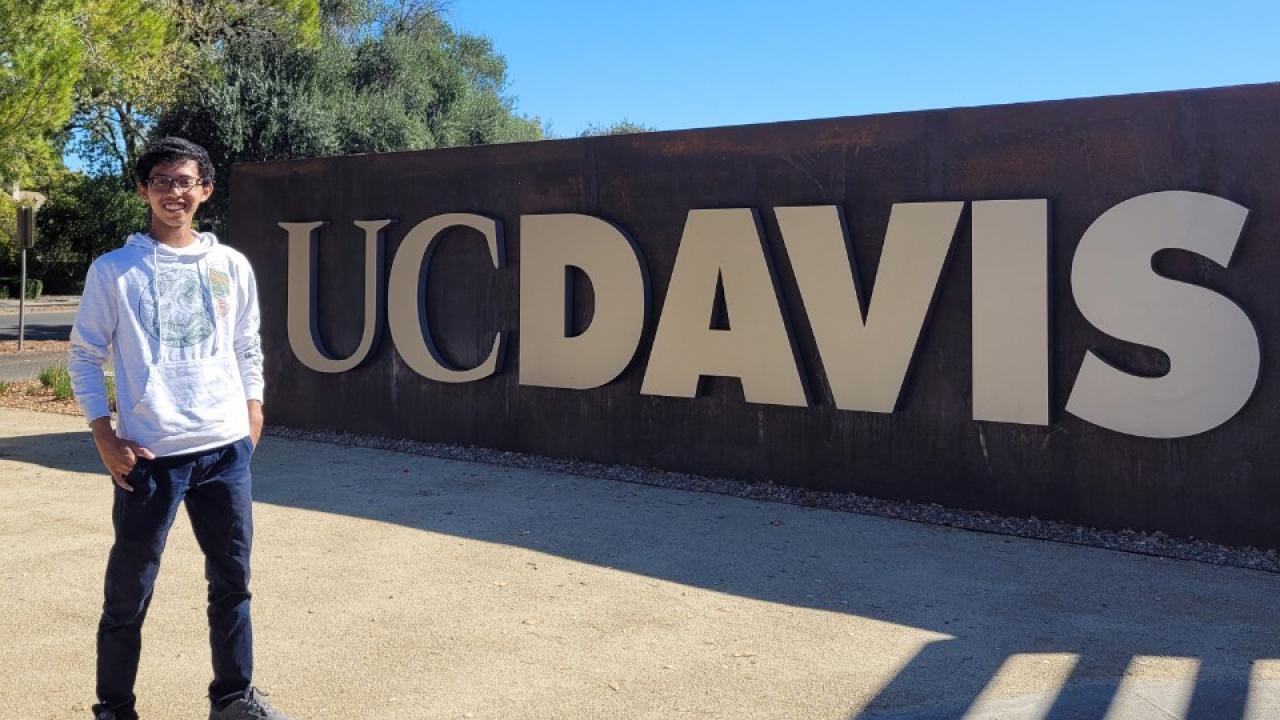 Global Study Program student Bimo Abdusshamad stands in front of a UC Davis sign on campus