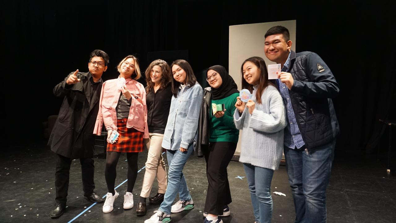 A small group of GSP students pose with the instructor on stage