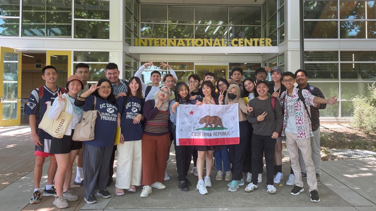 group of Indonesian students with California flag outside International Center