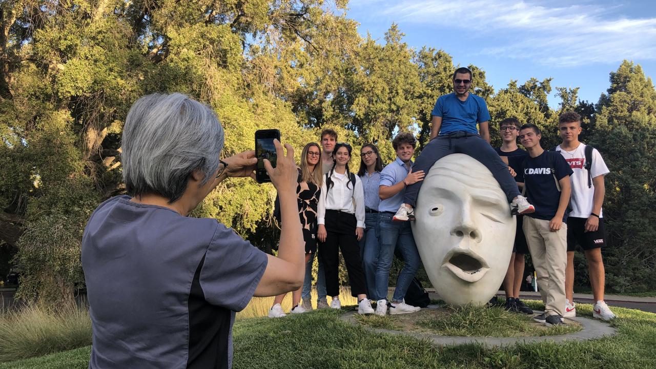 person taking photo of students by the See No Evil egghead at UC Davis