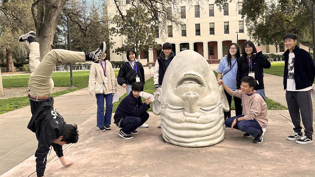 UC Davis international students pose in front of Eye on Mrak Egghead