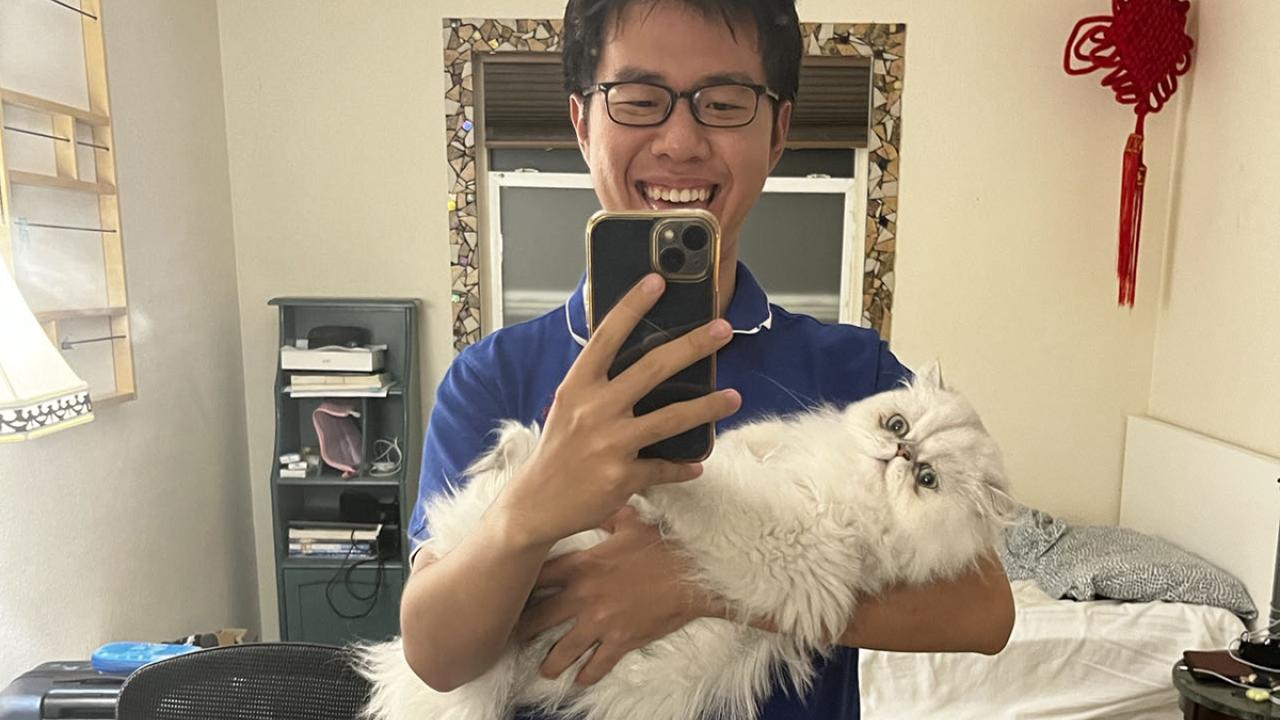 UC Davis GREAT research student takes a selfie with a cat at his homestay