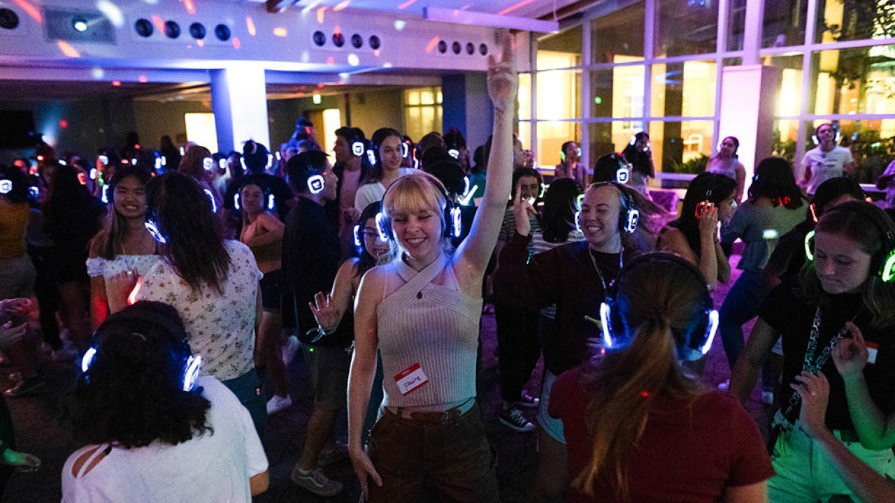 students dancing at a silent disco with headphones on