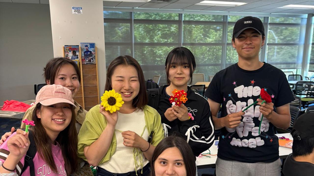 UC Davis international students pose with flowers they made for Mother's Day