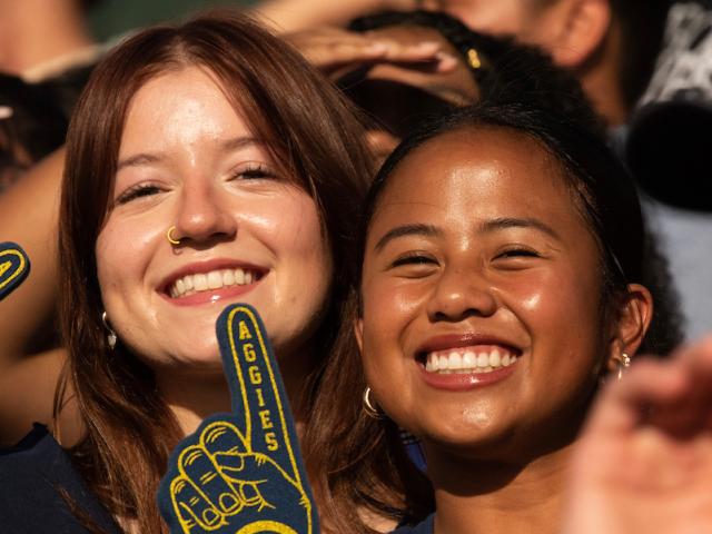 Two students cheer during a UC Davis Homecoming game