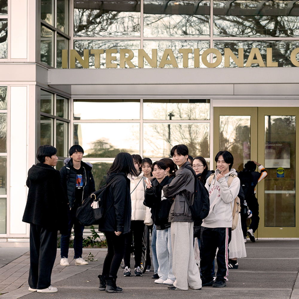 students chatting outside glass international center entrance
