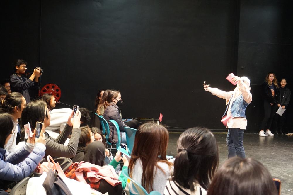 GSP student performs on stage as her classmates cheer her on