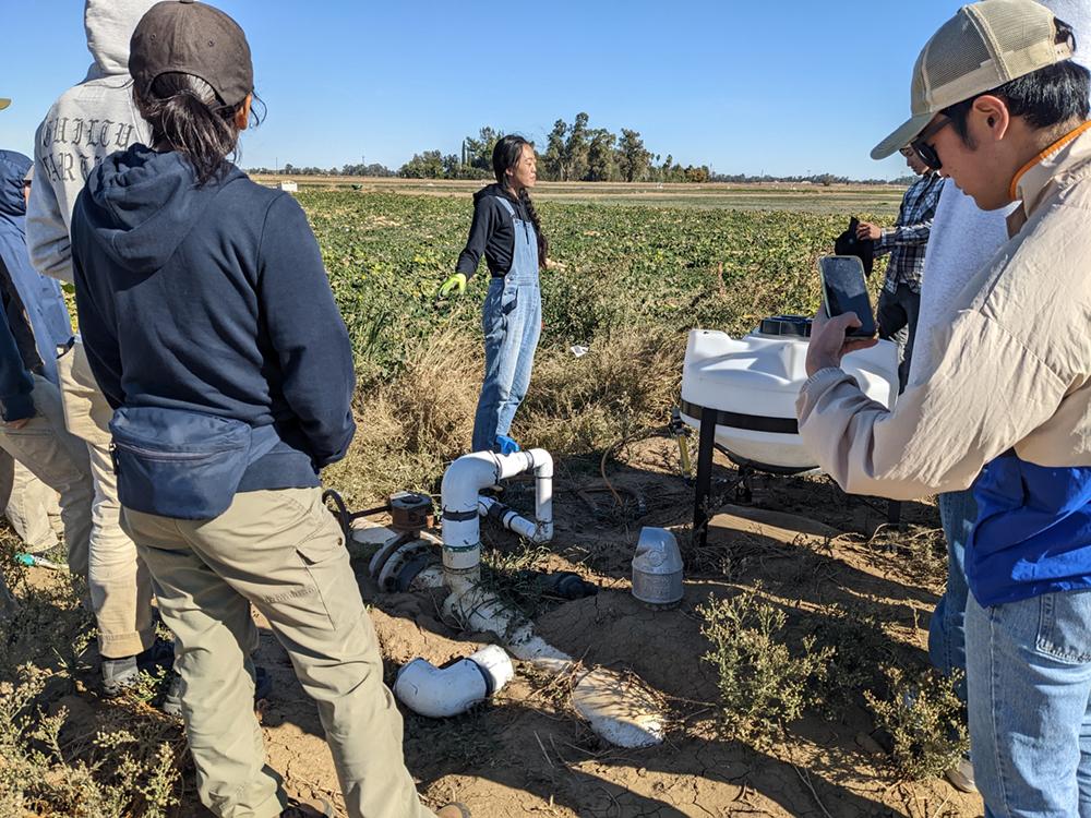 grad student Faye Duan teaches students about irrigation out in the field