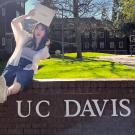 UC Davis Global Study Program student Akiho Nagahashi poses with her certificate on the UC Davis sign