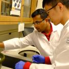 A GREAT program student and Professor Padavannil transfer a sample into the cooling bucket during their experiment