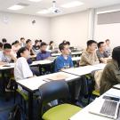 students fill a classroom at the UC Davis International Center as they sit and listen to a presentation
