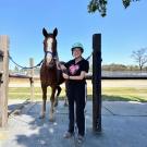 UC Davis GSP student Yizhou Liu poses with a horse during her horse riding class at the ARC