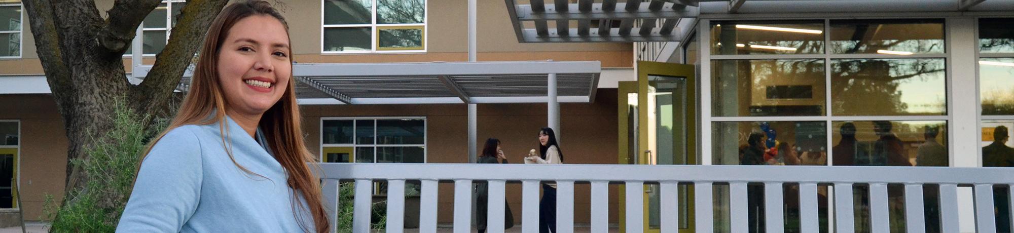 smiling student sitting on bench outside