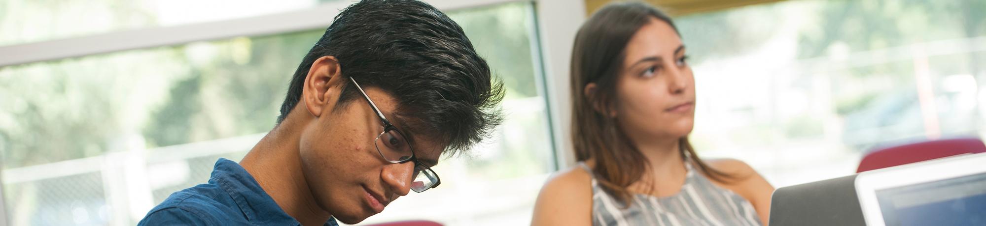 male and female student studying in classroom