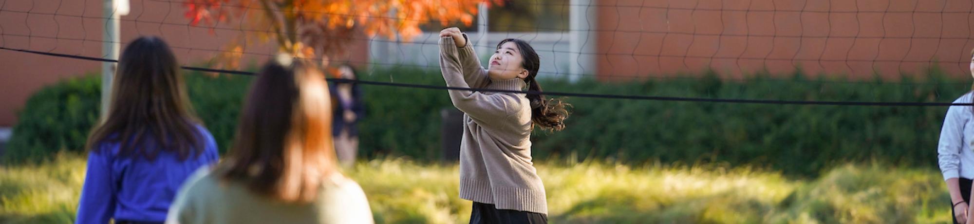 international students play volleyball outside the International Center
