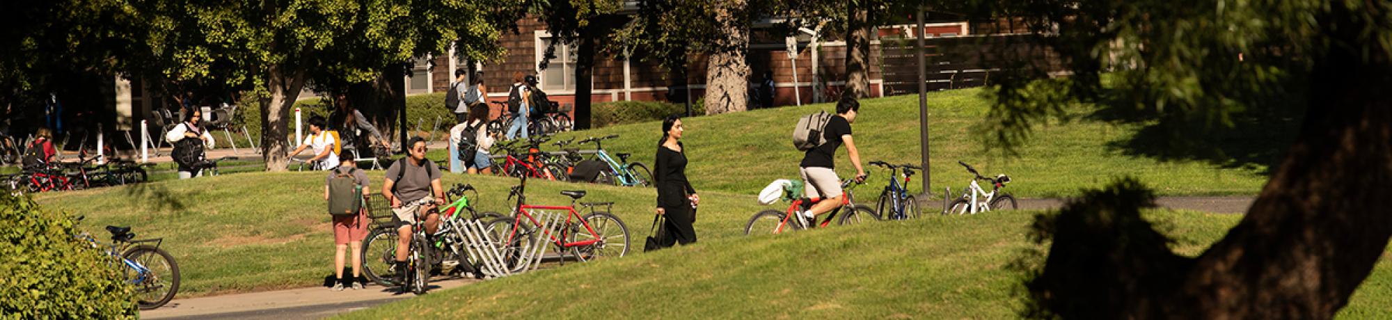 Students walk and ride across campus on a sunny day