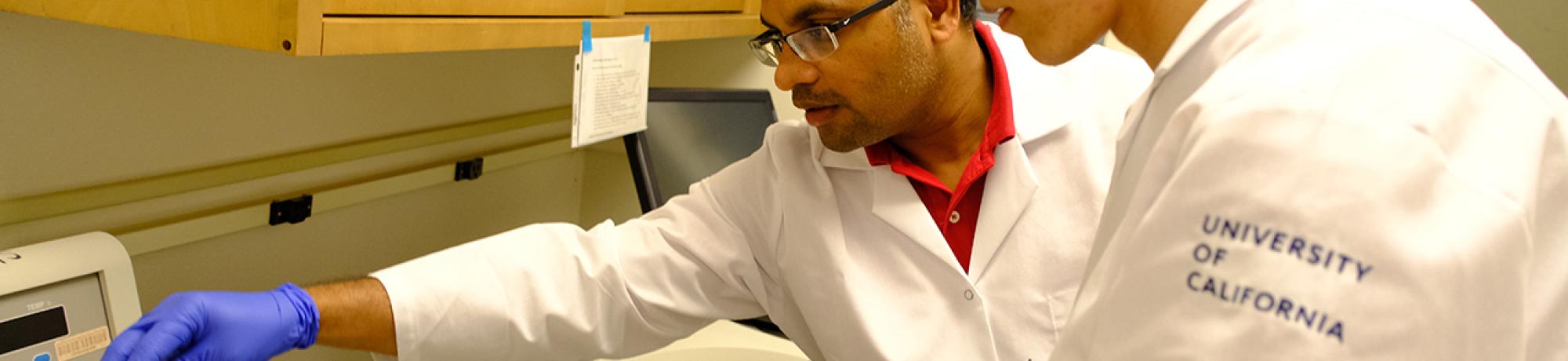 A GREAT program student and Professor Padavannil transfer a sample into the cooling bucket during their experiment