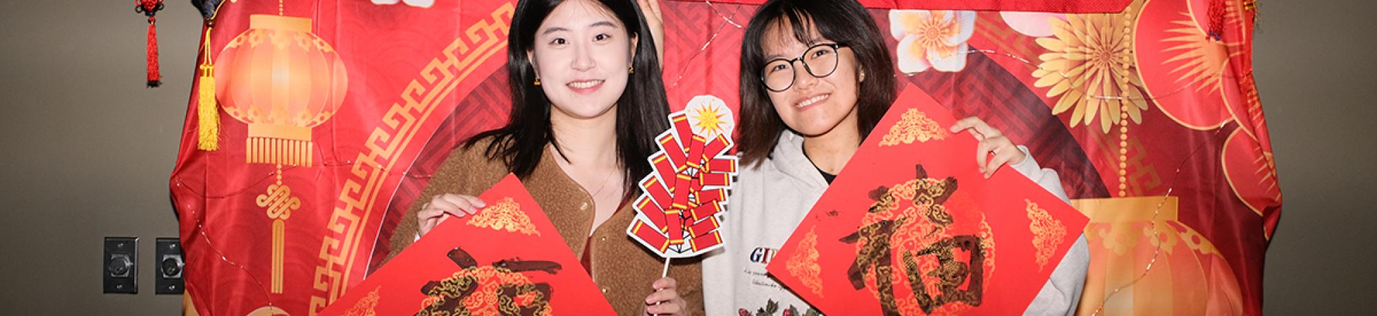 Two GSP students pose with Chinese calligraphy during the Lunar New Year celebration at the International Center UC Davis.